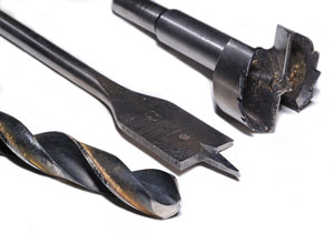 three drill bits - twist drill bit, spade drill bit, and forstner drill bit